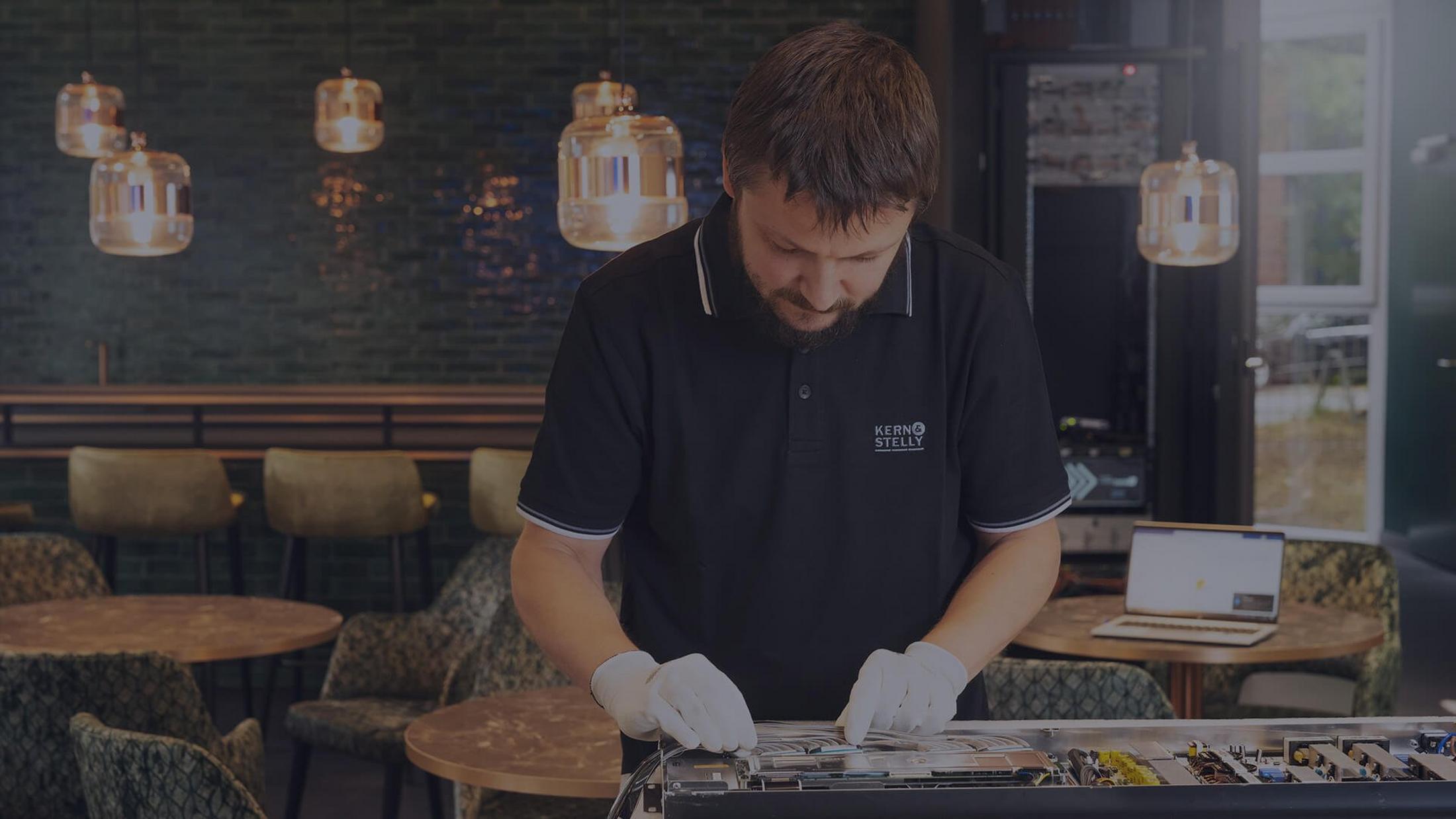 a man in a black shirt working on a laptop 