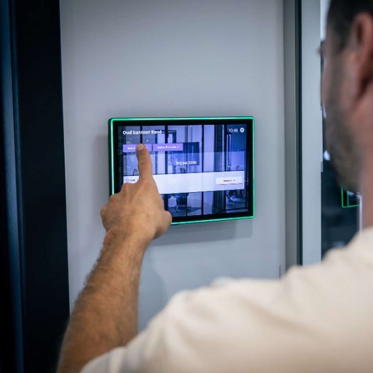 Woman in an office booking a meeting room via a desk booking system Woman in an office booking a meeting room via a desk booking system