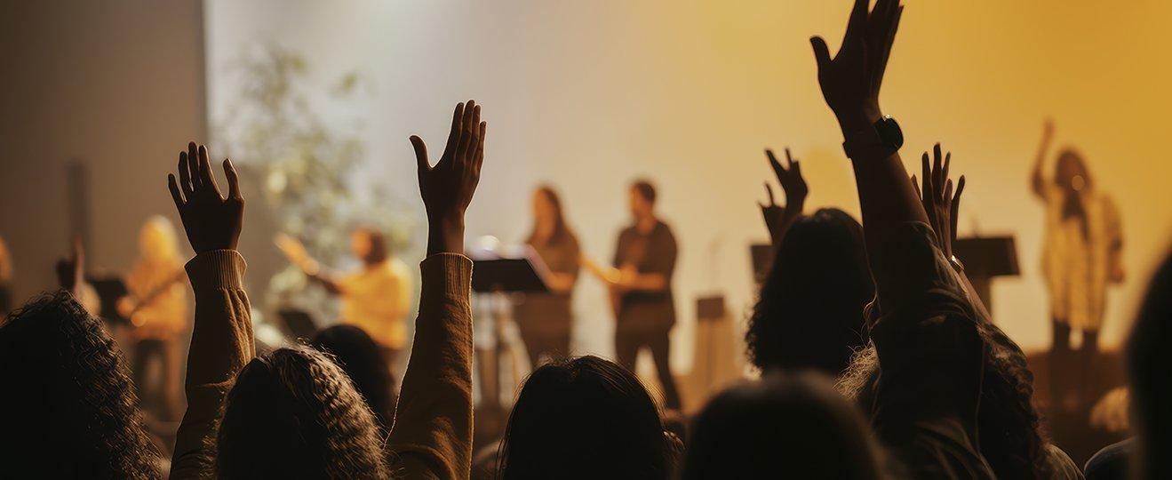 a group of people raising their hands in the air at a concert