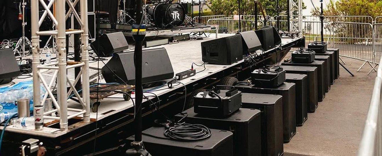 a stage with a bunch of speakers and a bunch of people