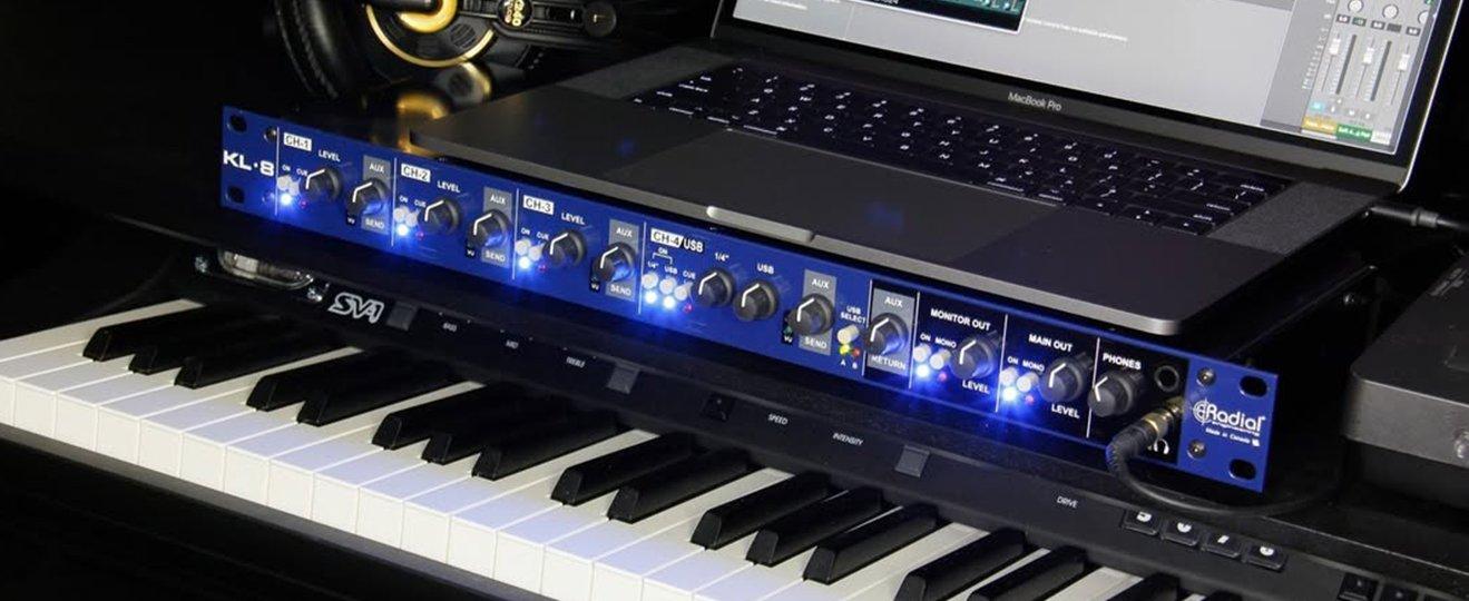 a laptop computer sitting on top of a keyboard and a music stand