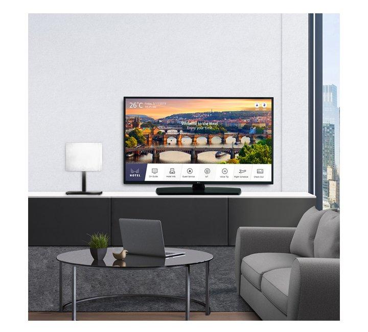 a living room with a large flat screen tv and a laptop