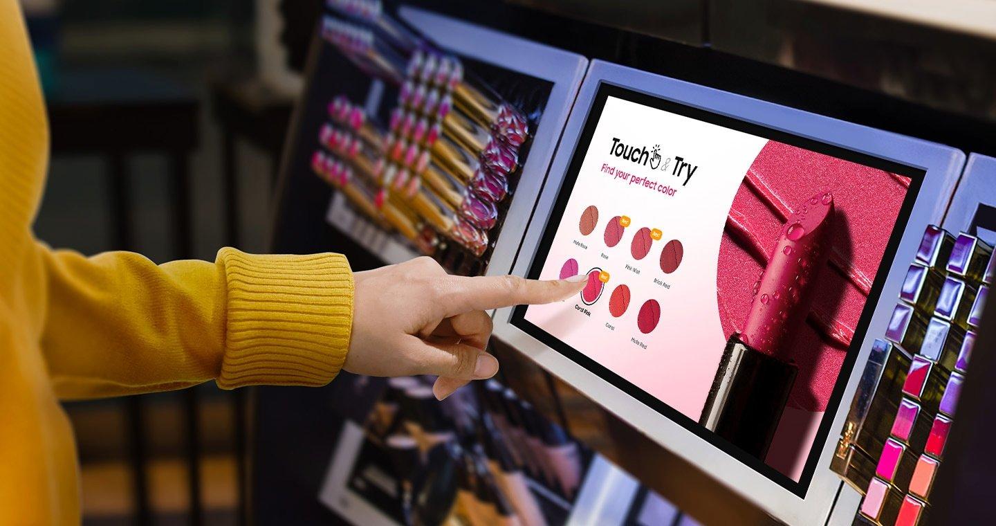 a woman is pointing at a screen with lipstick on it