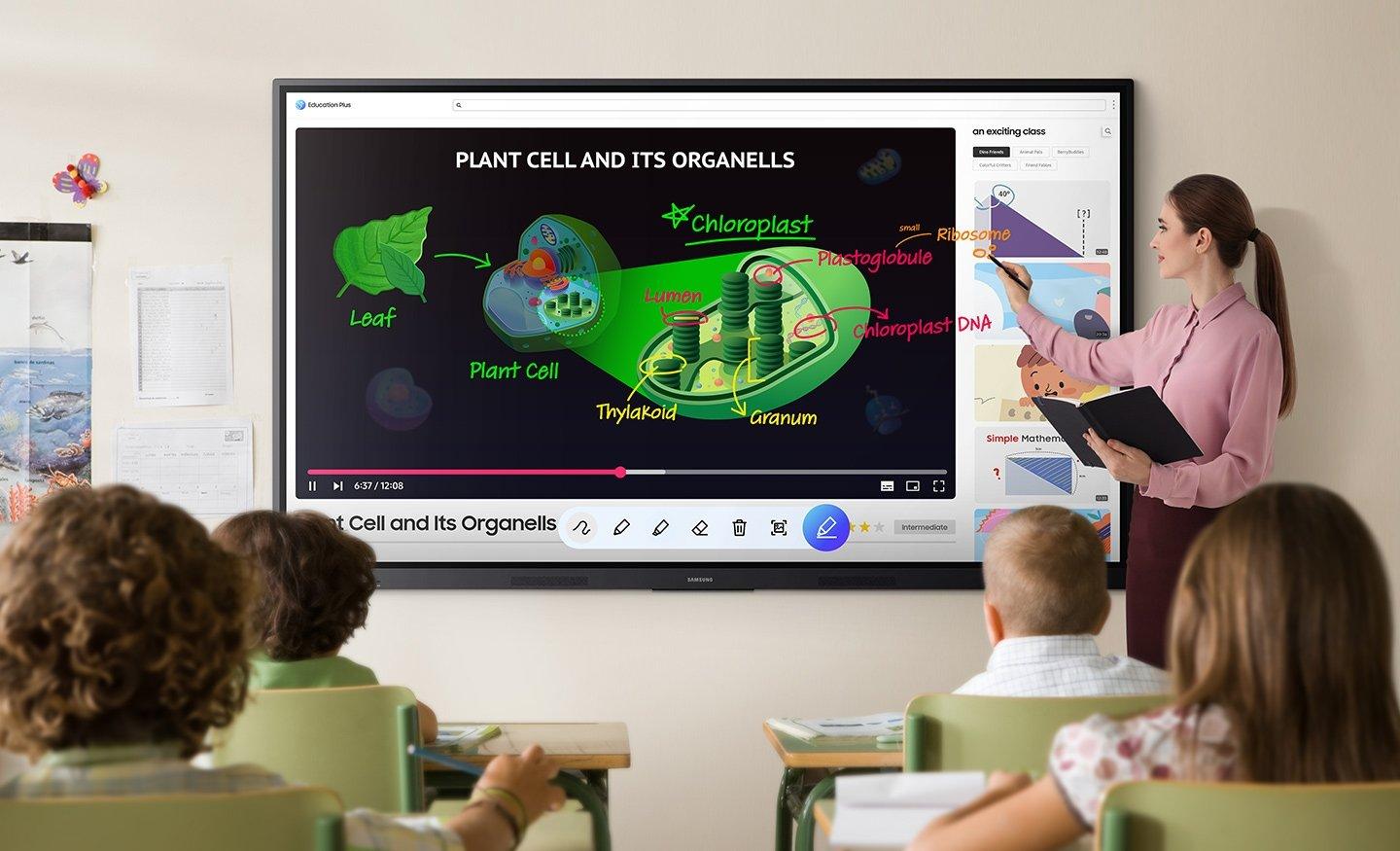 a group of children sitting in front of a large screen