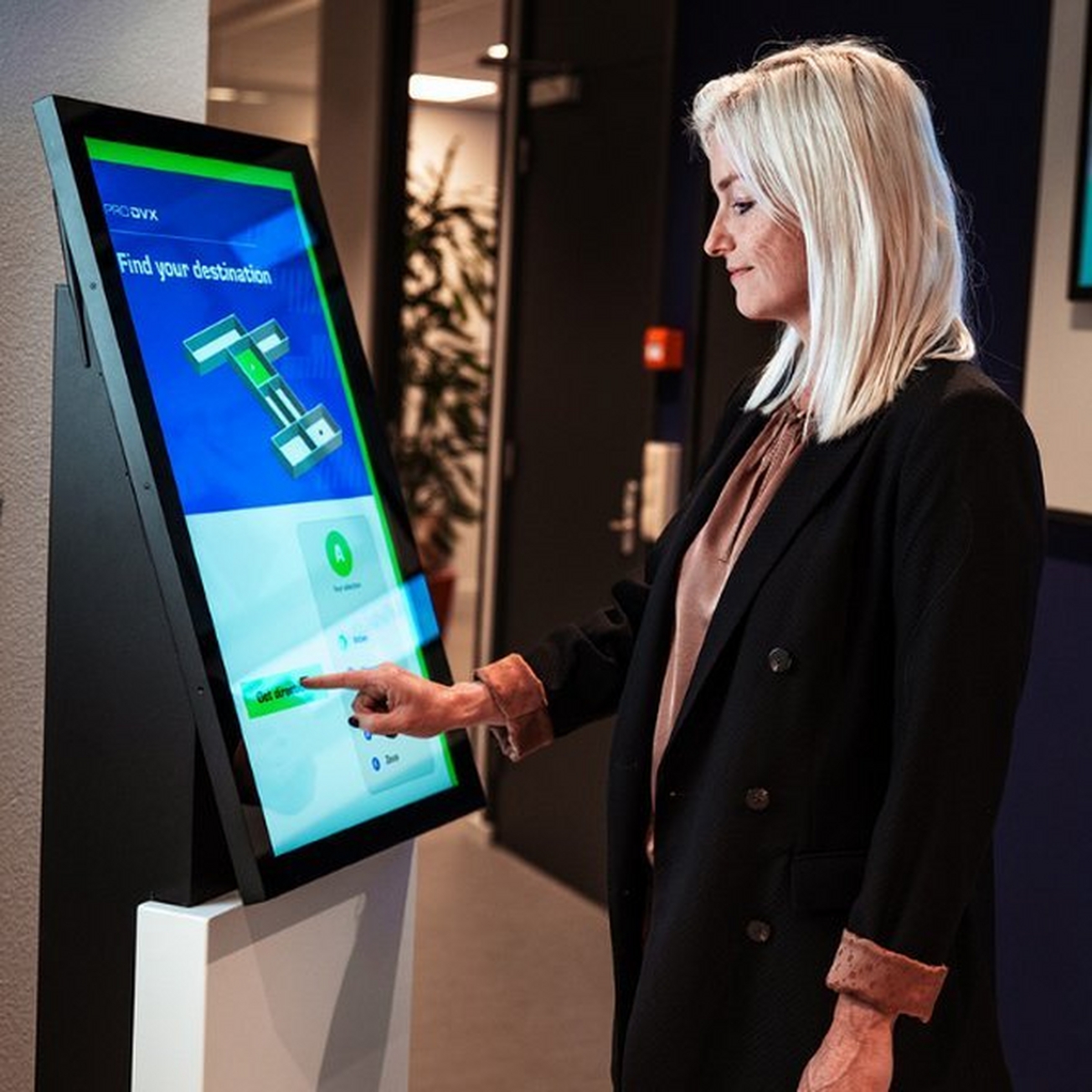 woman finding her way in an office by using a digital display woman finding her way in an office by using a digital display