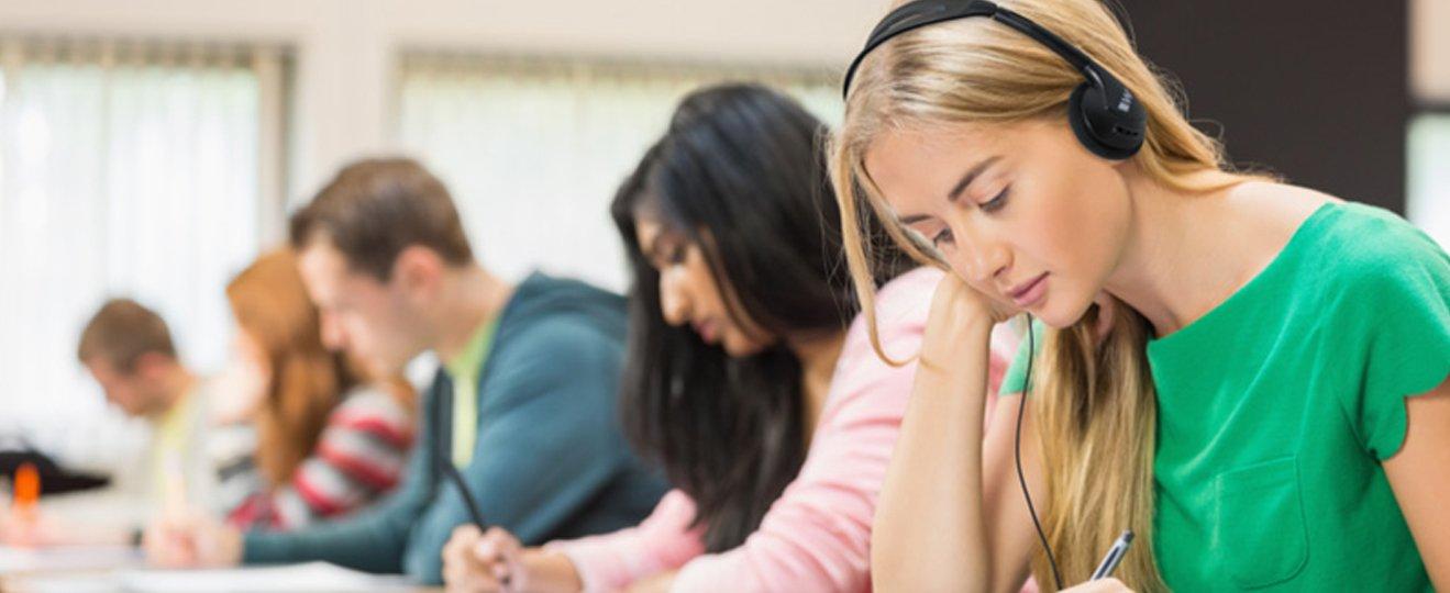 a group of students sitting at desks with headphones on