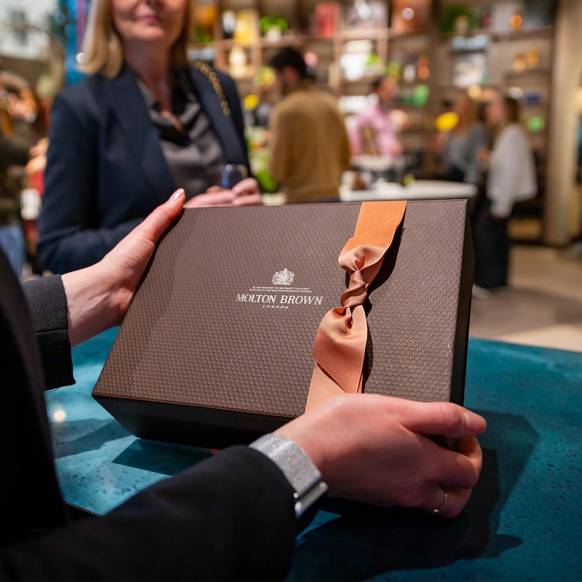 Molton Brown gift box with ribbon presented in store.