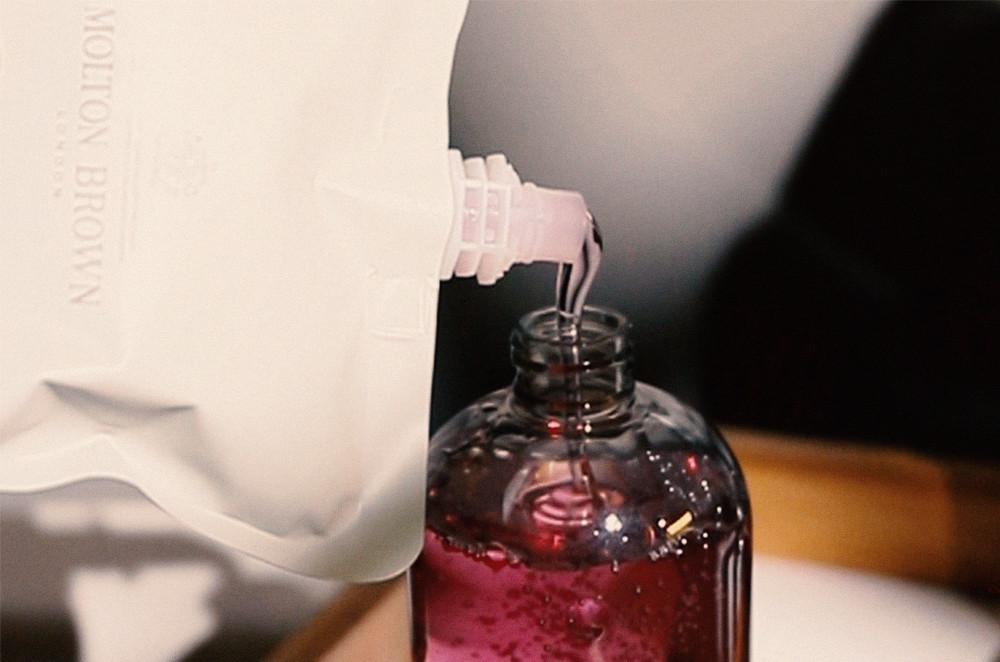 An image of body wash refill pouch is refilling a body wash bottle