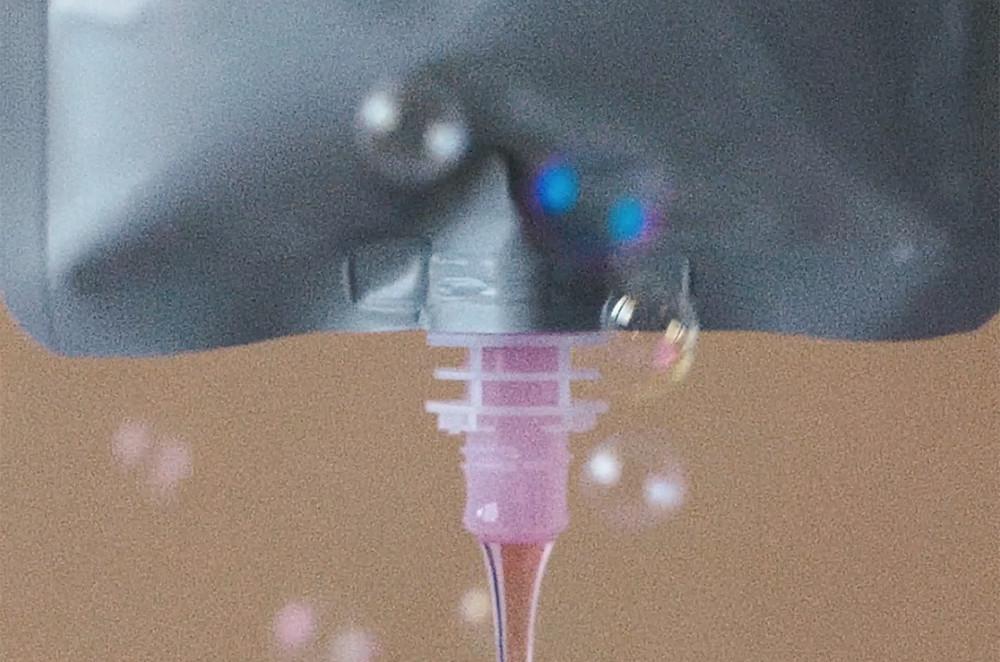 A close up image of hand wash gel coming out of a hand wash refill pouch upside down