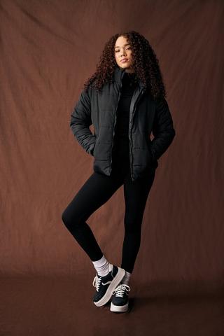 Girl In Black Leggings, Red Blouse And White Sneakers Stock Photo