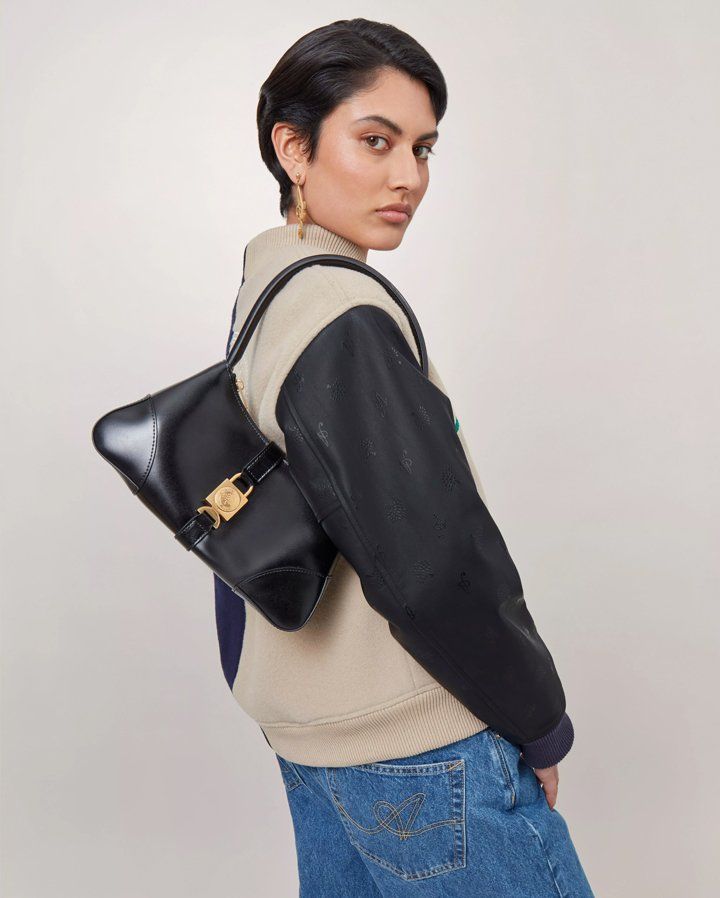 Model wearing Axel Arigato for Mulberry Top Handle Bag