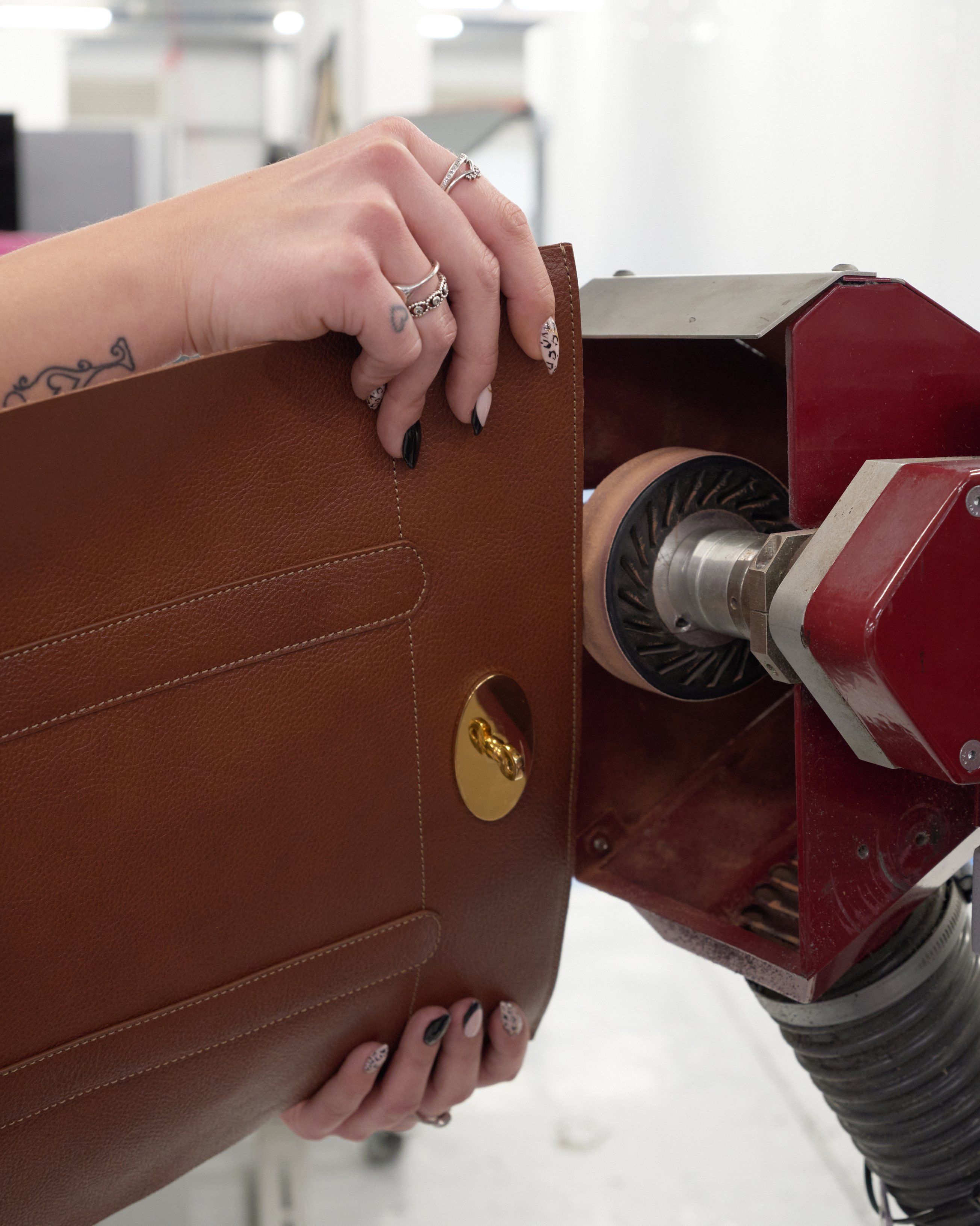 The edge of a leather panel is smoothed, a process known as “emery”.