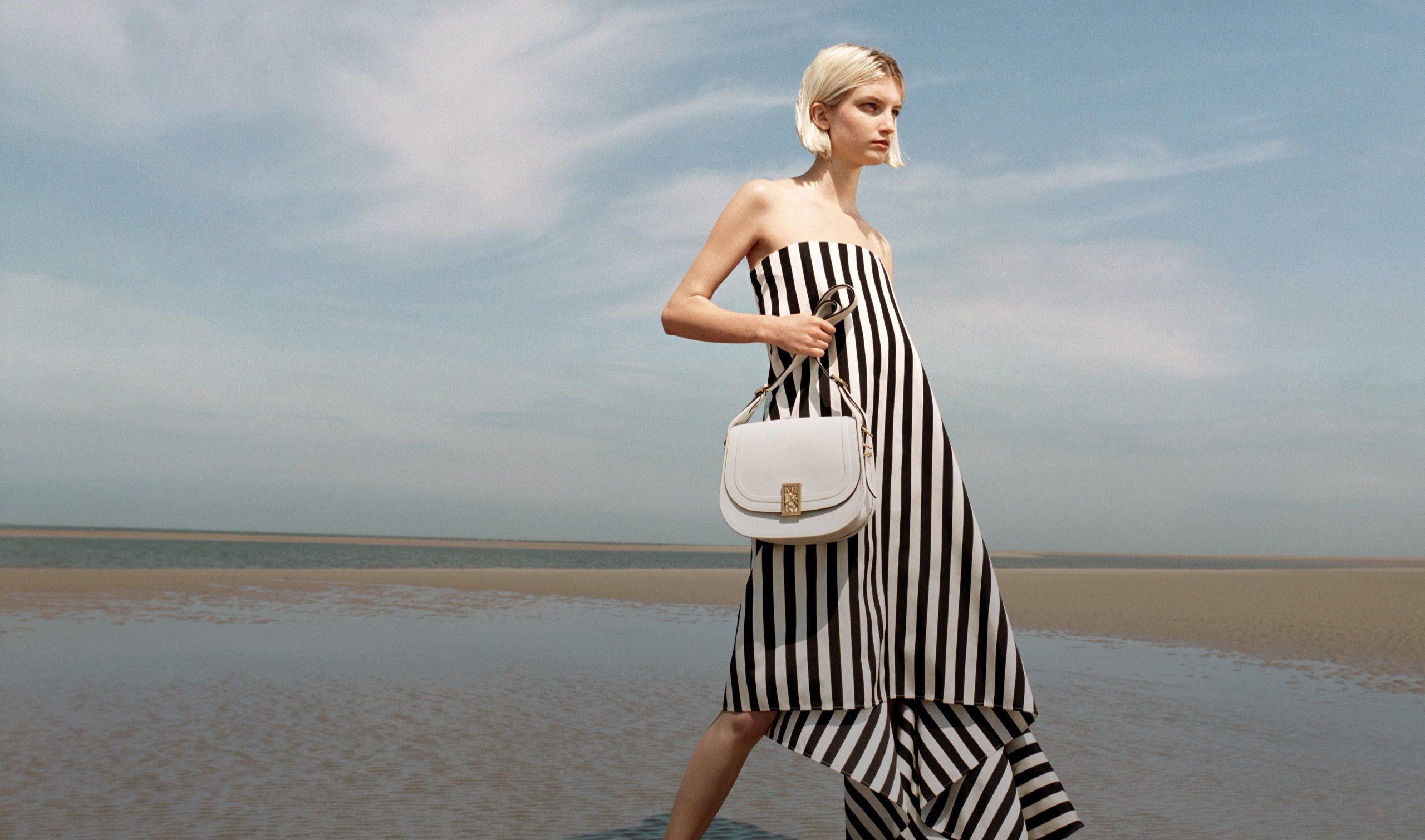 Model holding a Sadie bag in white leather