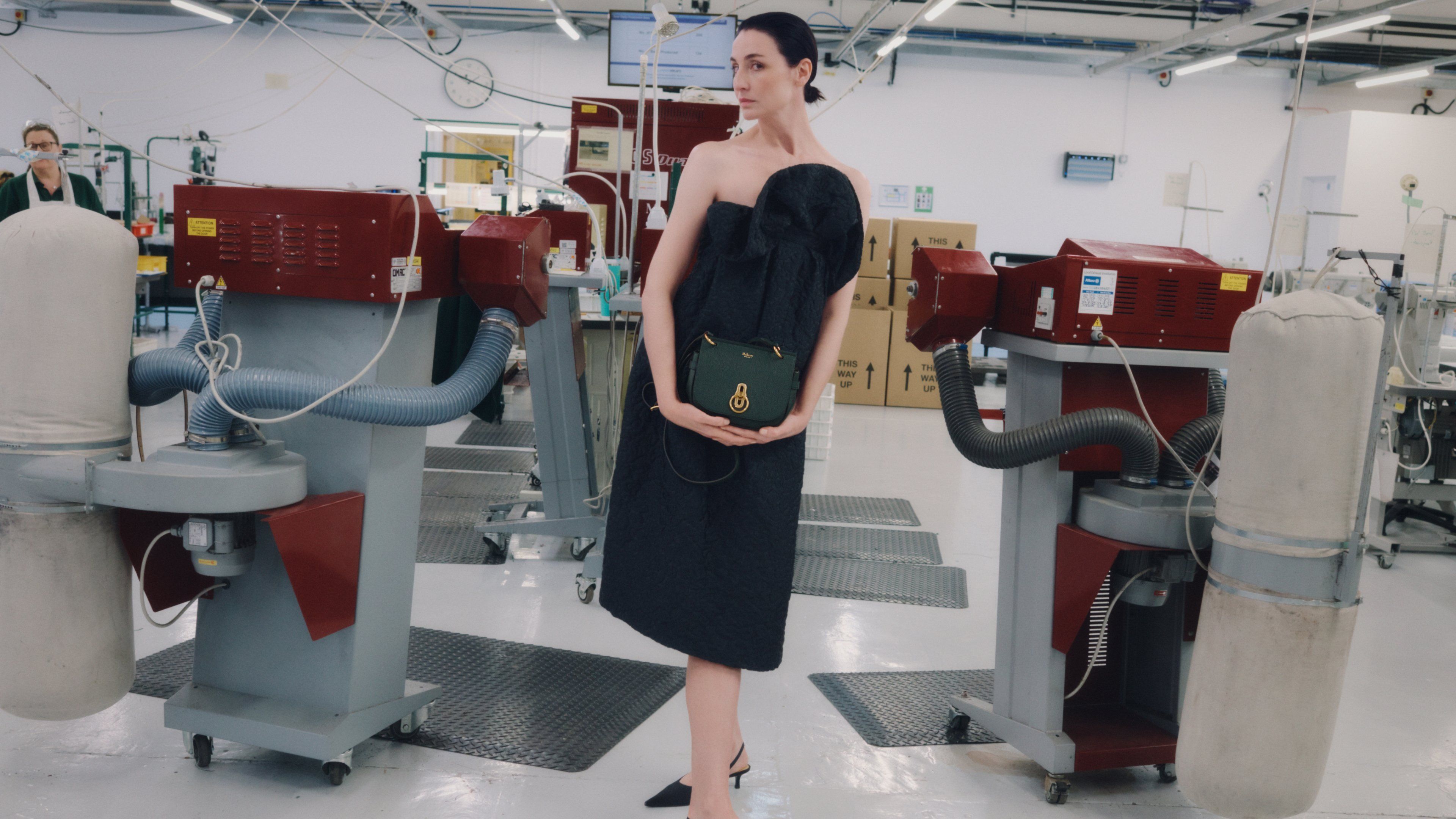 Female model wearing Mulberry Small Amberley Satchel in dark green leather