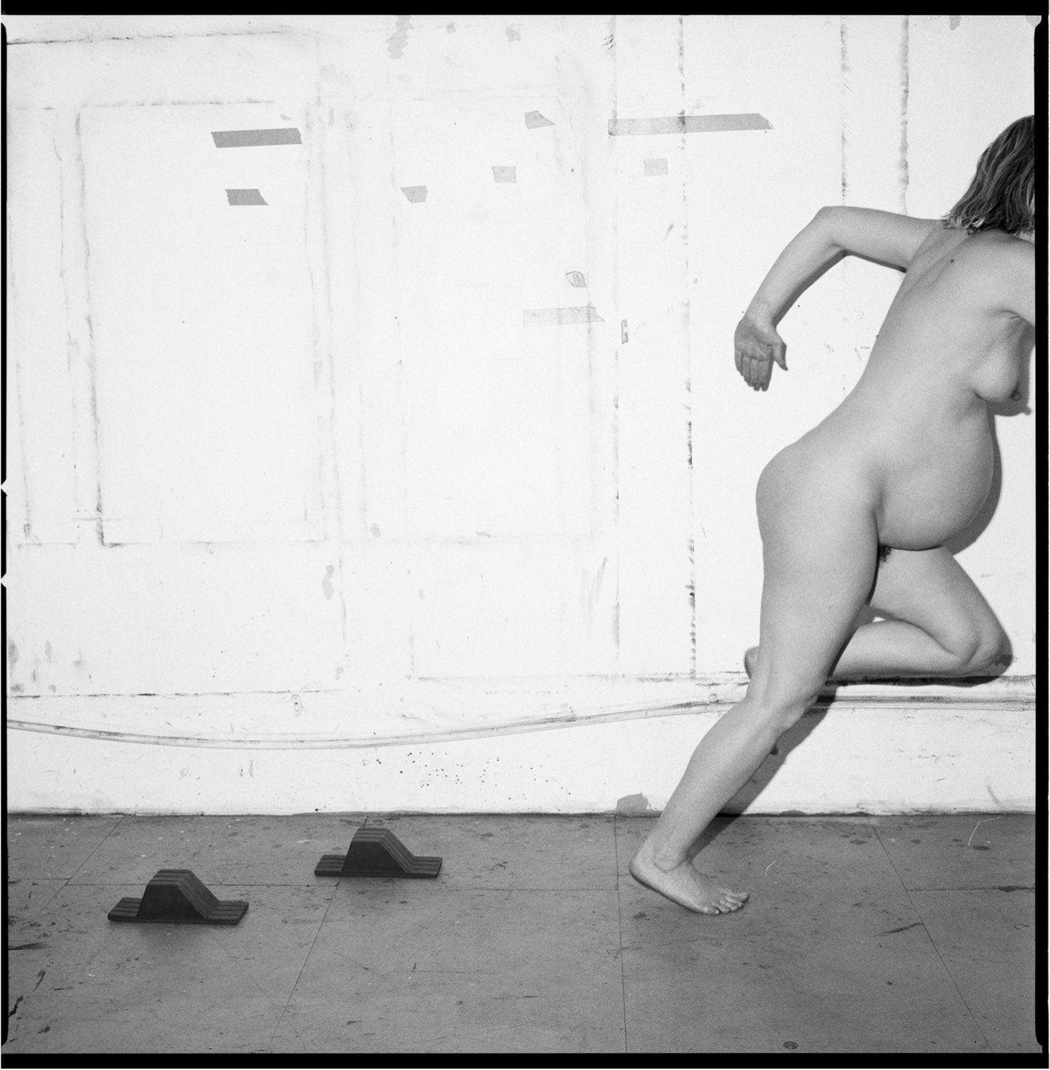 Black and white photography of a pregnant woman running