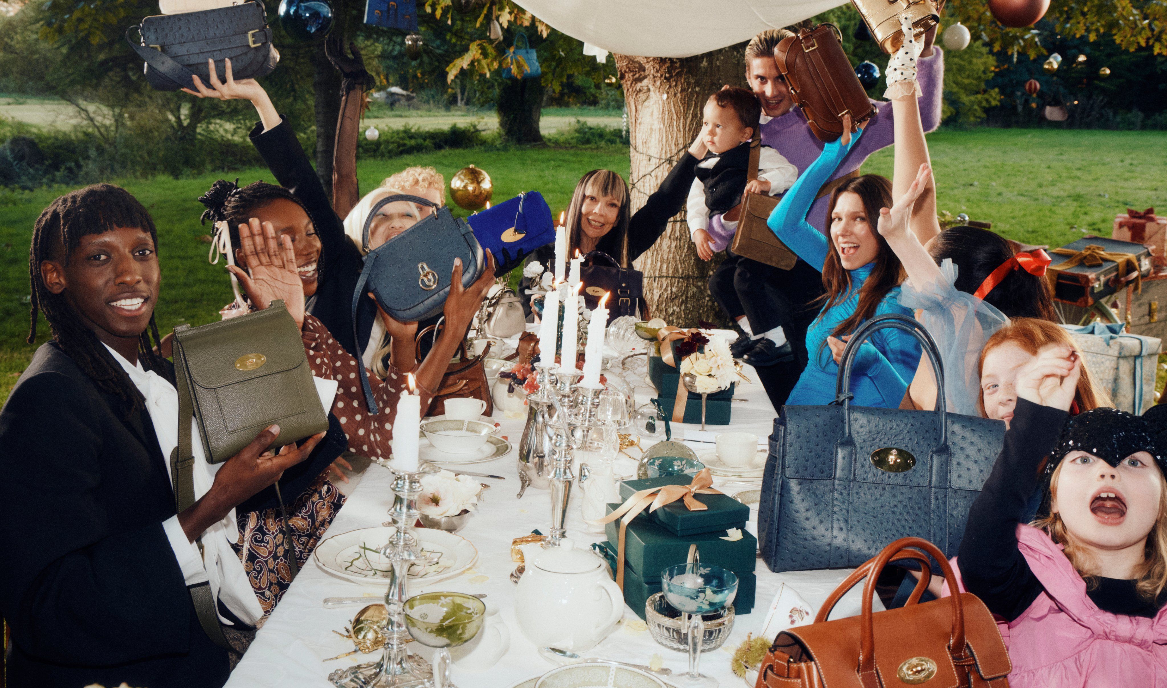 Group shot of people at table waving Mulberry handbags