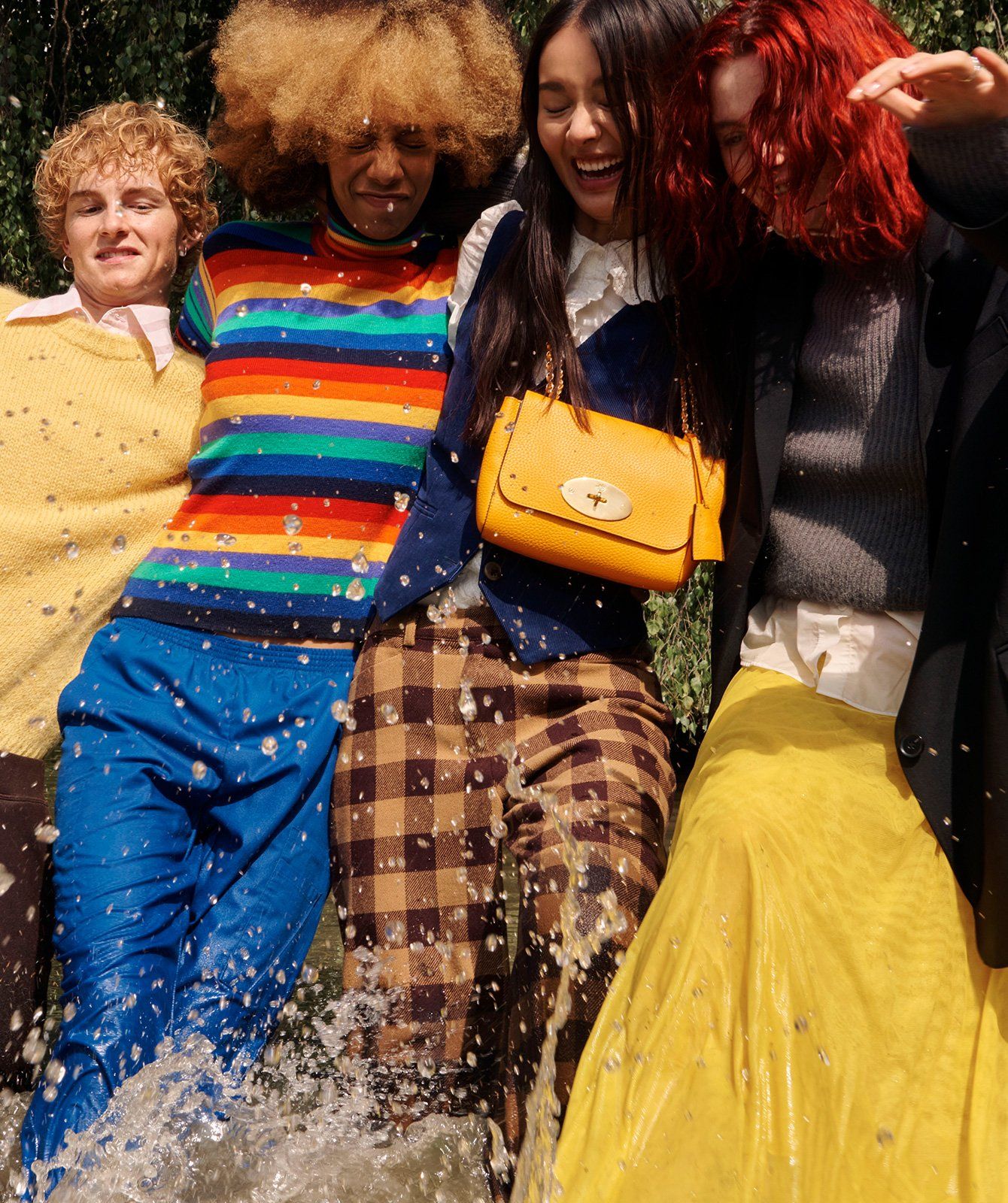 Four models standing together with one yellow Lily handbag