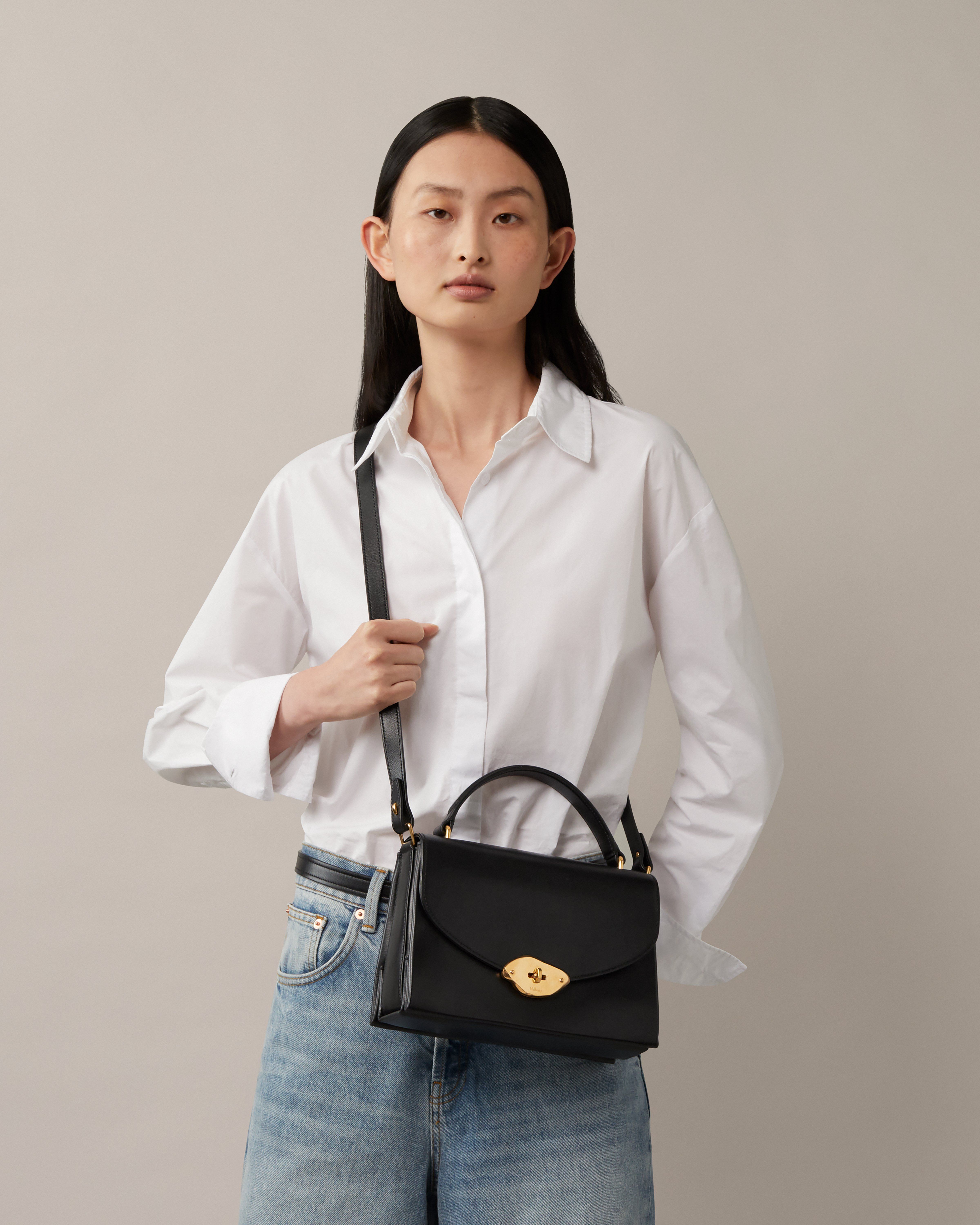 Model trägt eine Mulberry-Lana-Tasche mit Henkel in Schwarz
