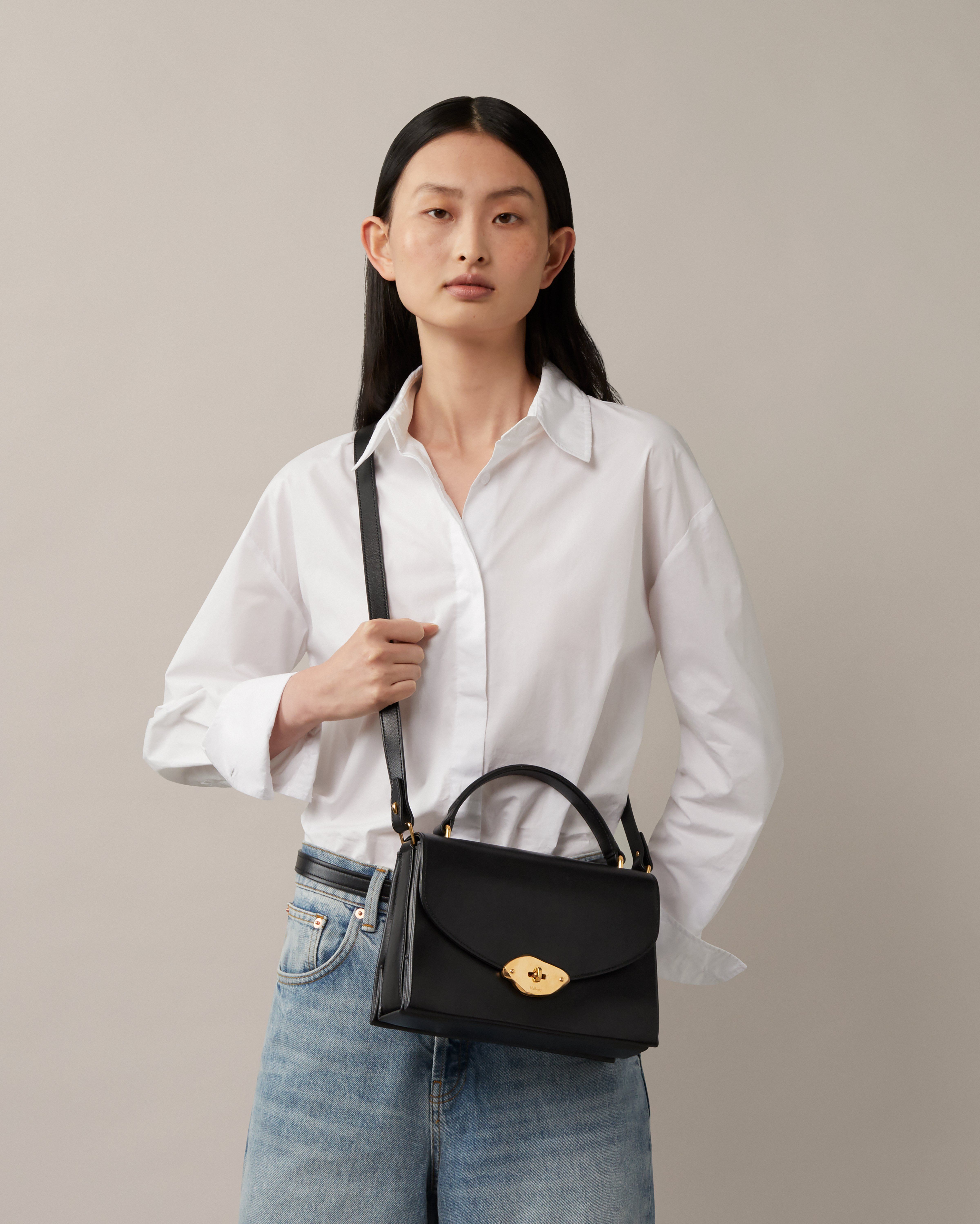 Model trägt eine Mulberry-Lana-Tasche mit Henkel in Schwarz