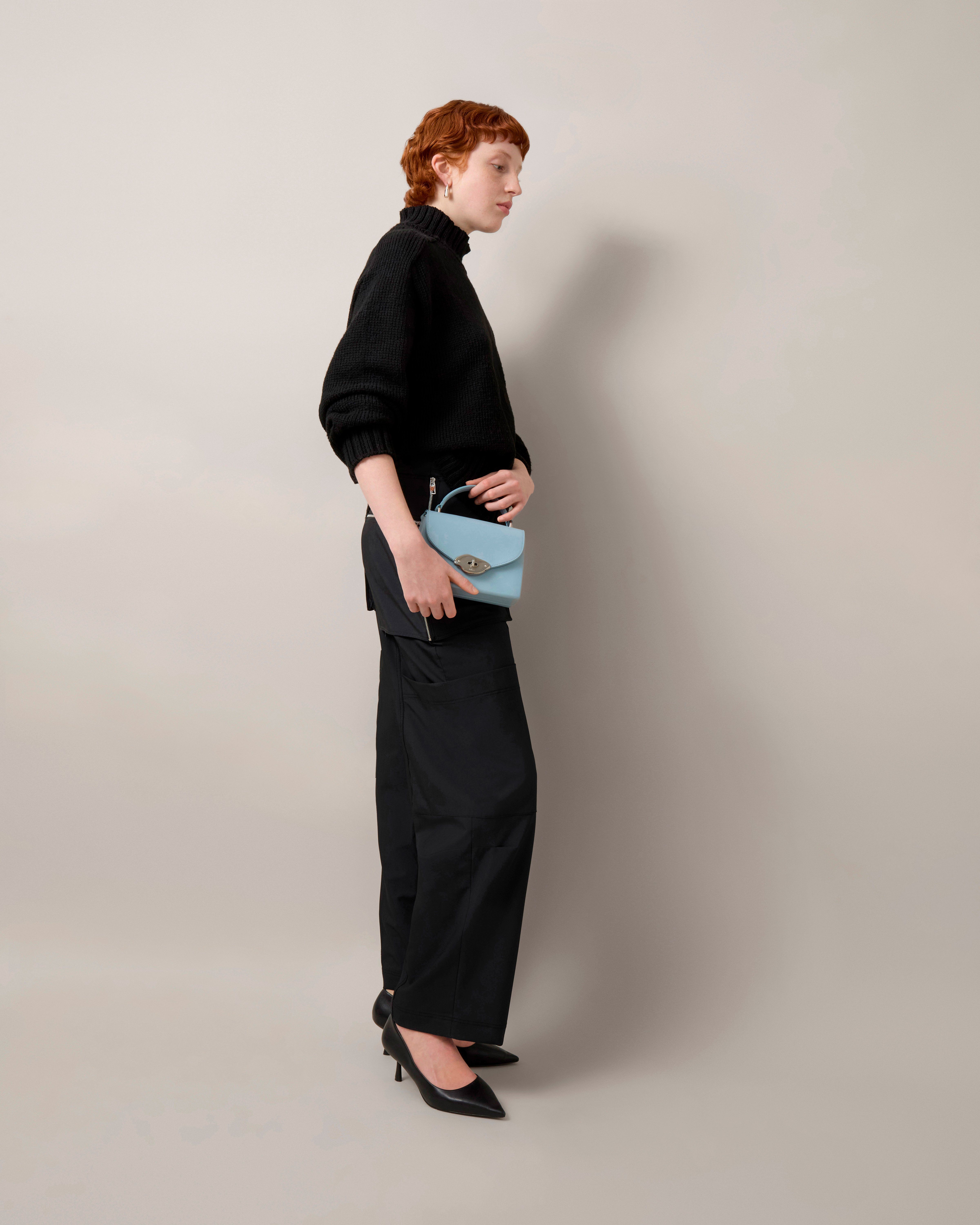 Model mit kleiner Lana Top Handle Tasche aus Hochglanzleder in Popelin Blau