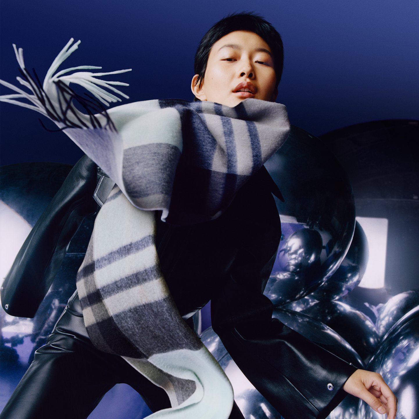 Model wearing a Mulberry check scarf in navy and light blue
