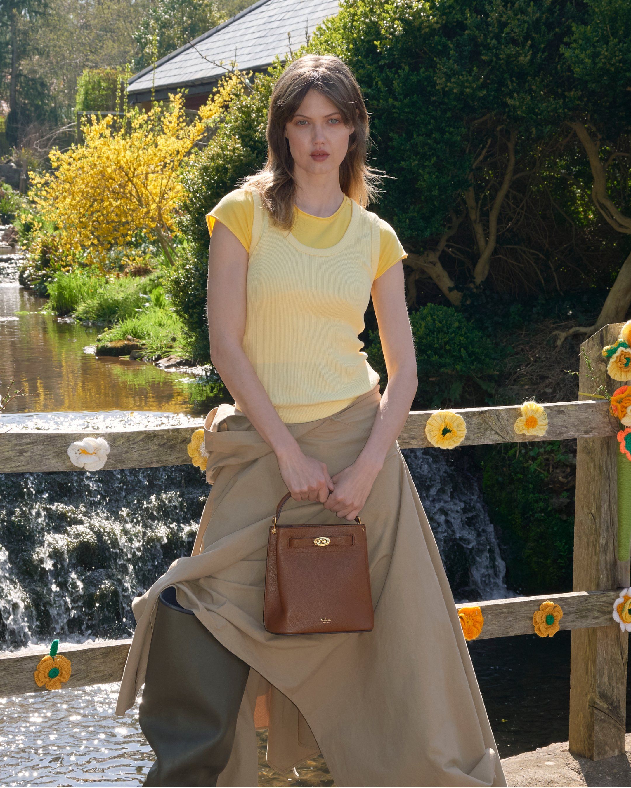 Female model wearing Mulberry Islington bucket bag in oak brown leather