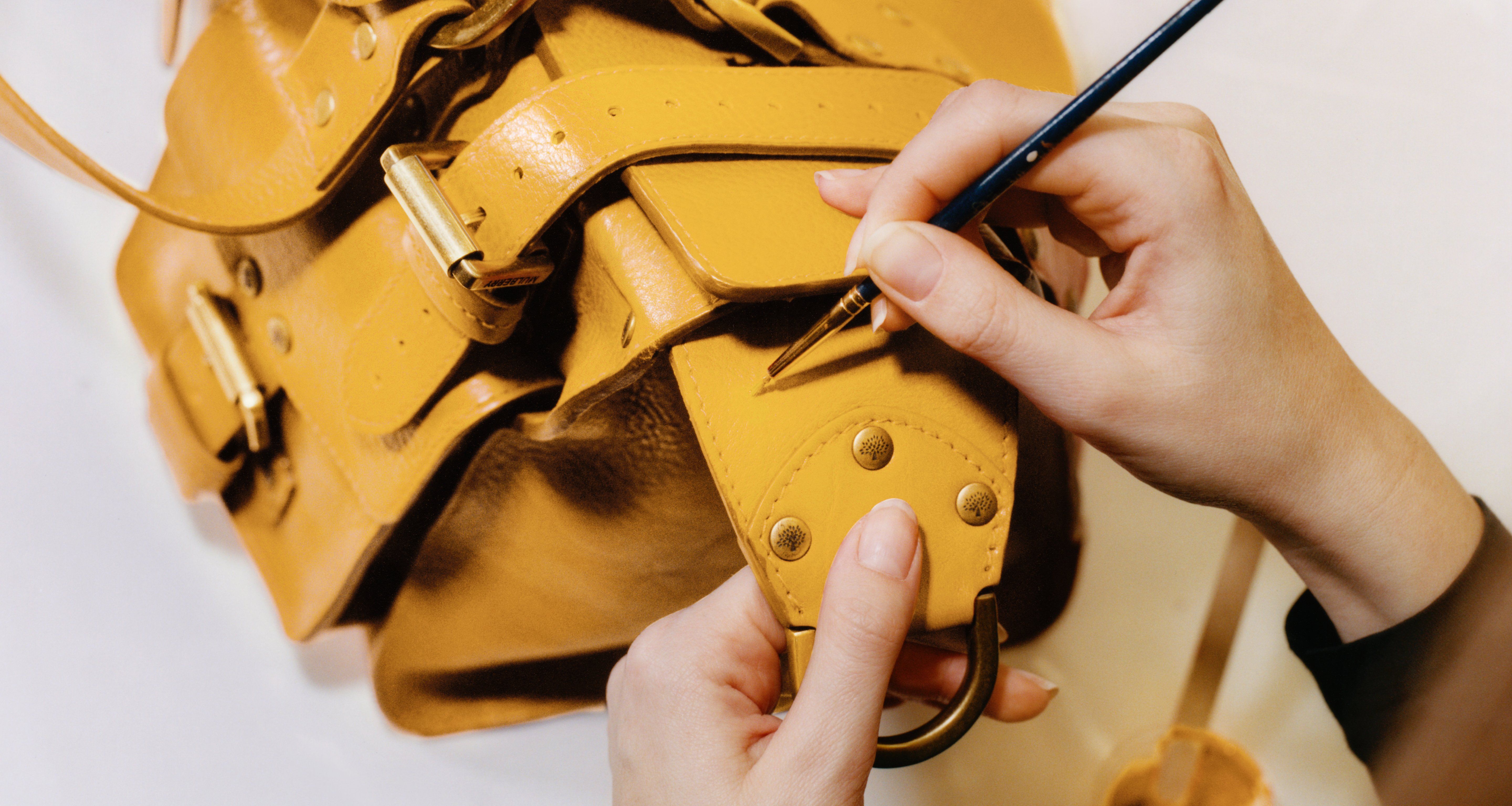 Person, die eine Mulberry-Handtasche restauriert