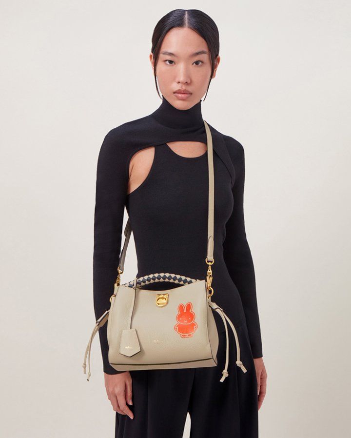 model wearing mulberry small iris bag in chalk with orange miffy character print