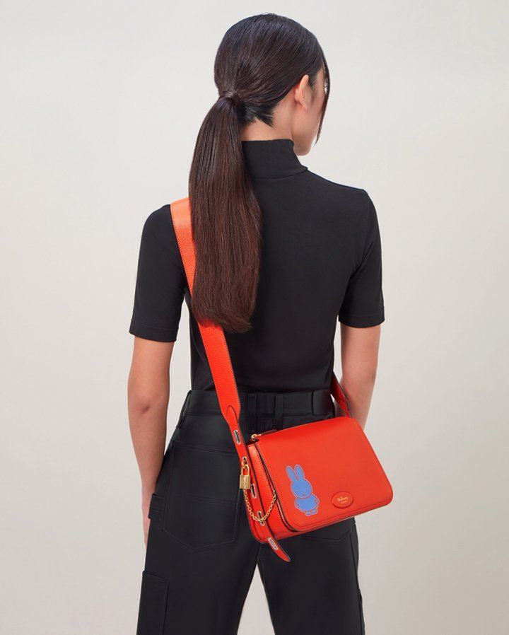 model wearing mulberry billie bag in orange with blue miffy character print
