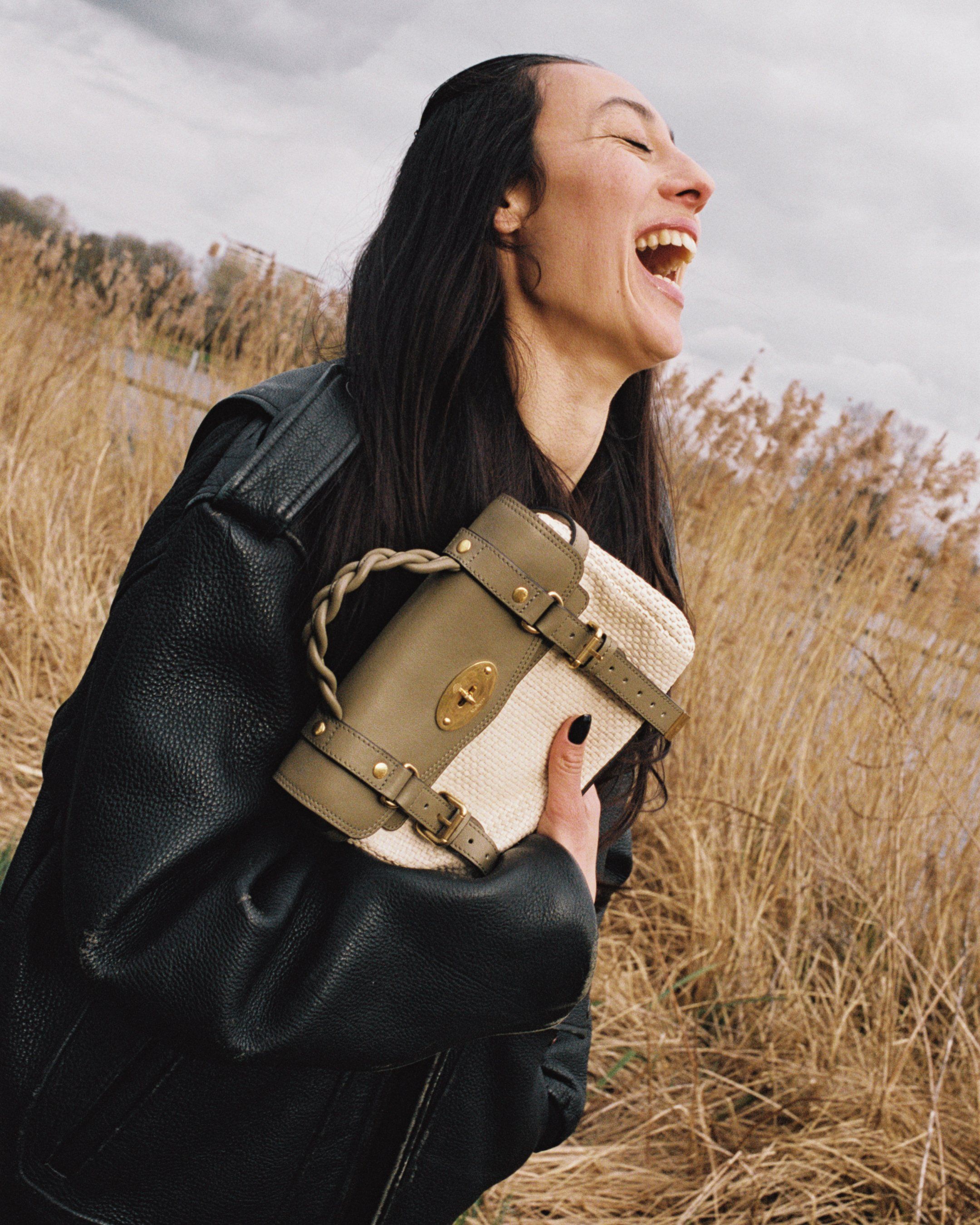 Model holding the Mulberry Mini Alexa bag in raffia and khaki leather