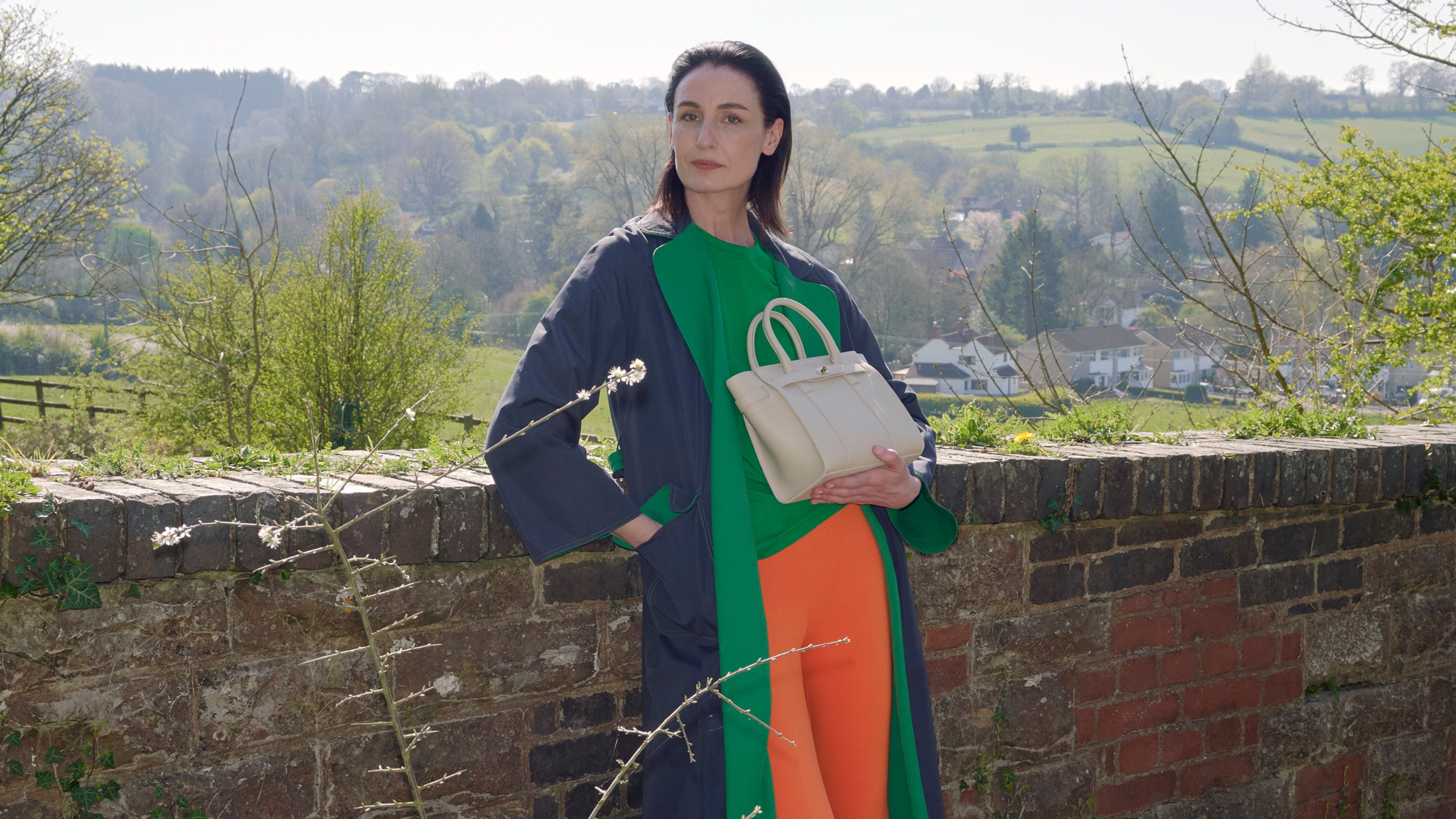 Model holding the Mulberry Mini Zipped Bayswater bag in beige leather