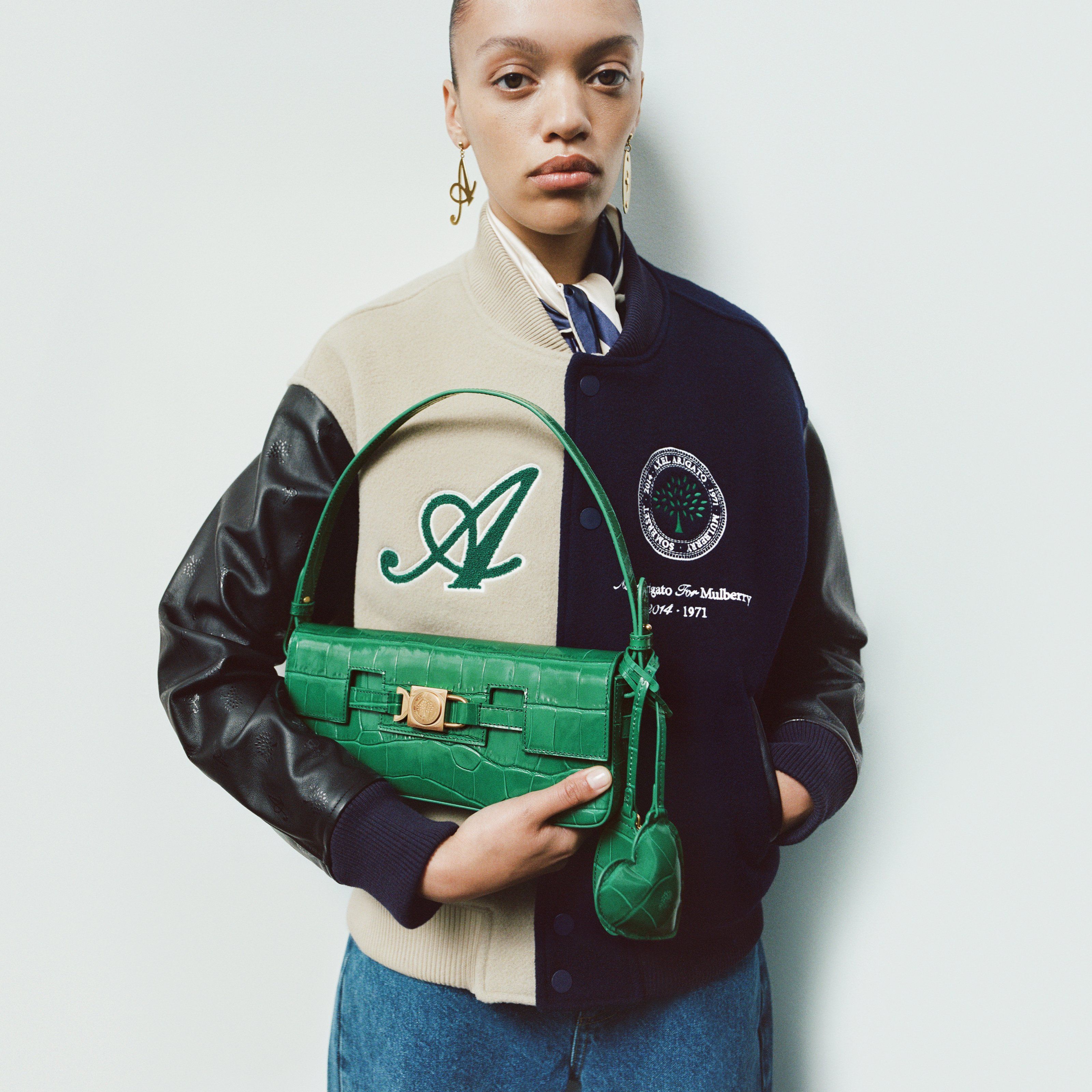 model holding axel arigato for mulberry shoulder bag in emerald green