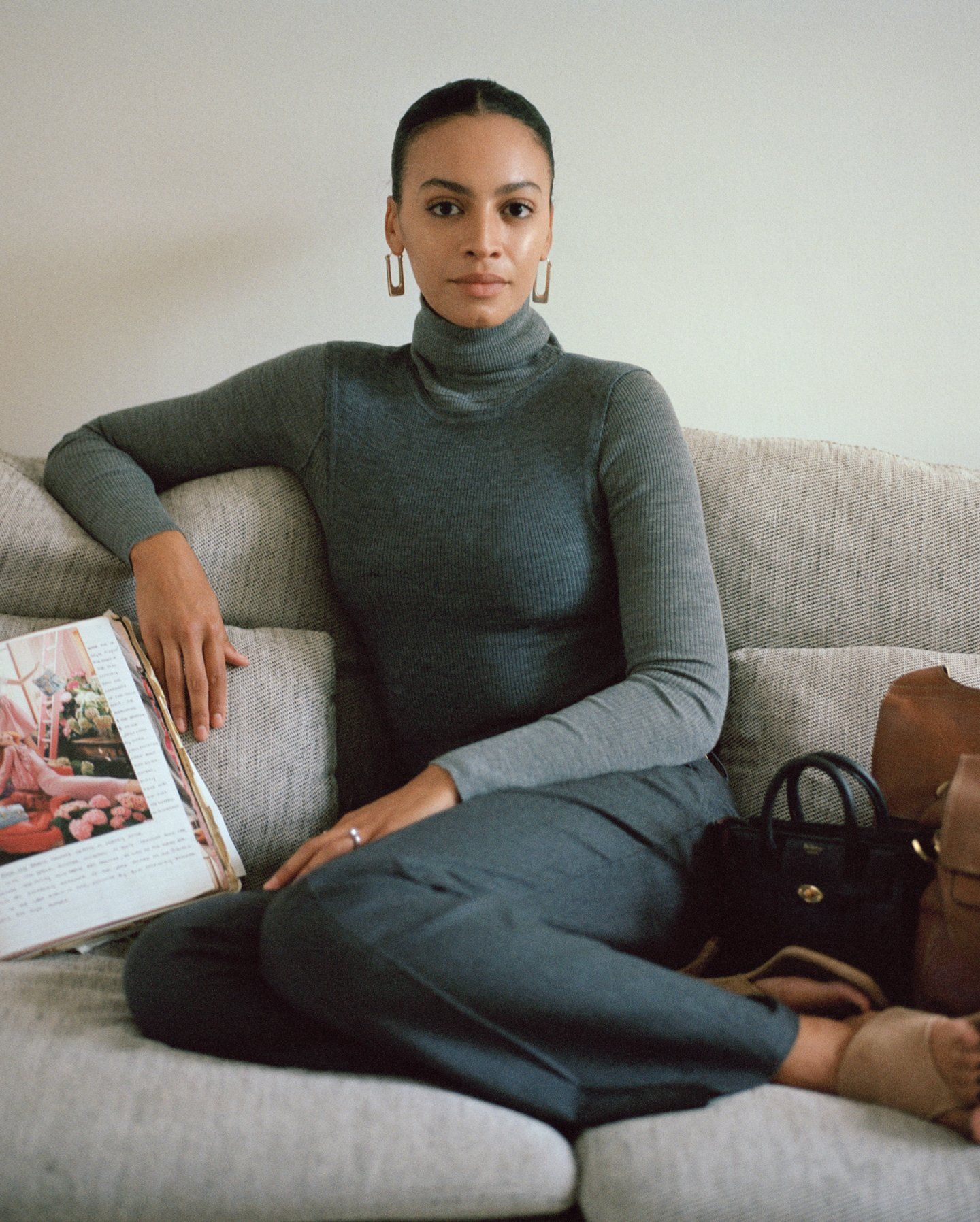 Woman in a grey jumper sitting on a sofa