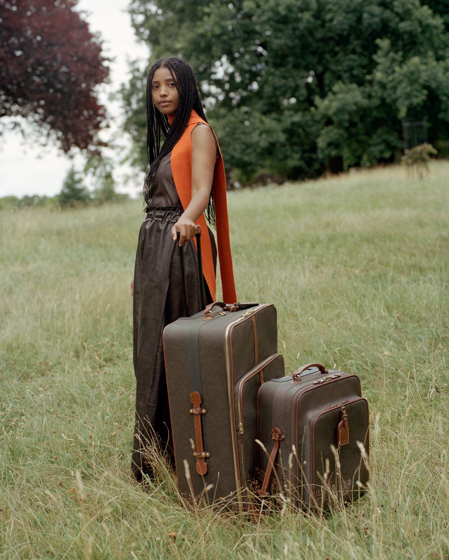 Woman standing outside with two brown Mulberry suitcases
