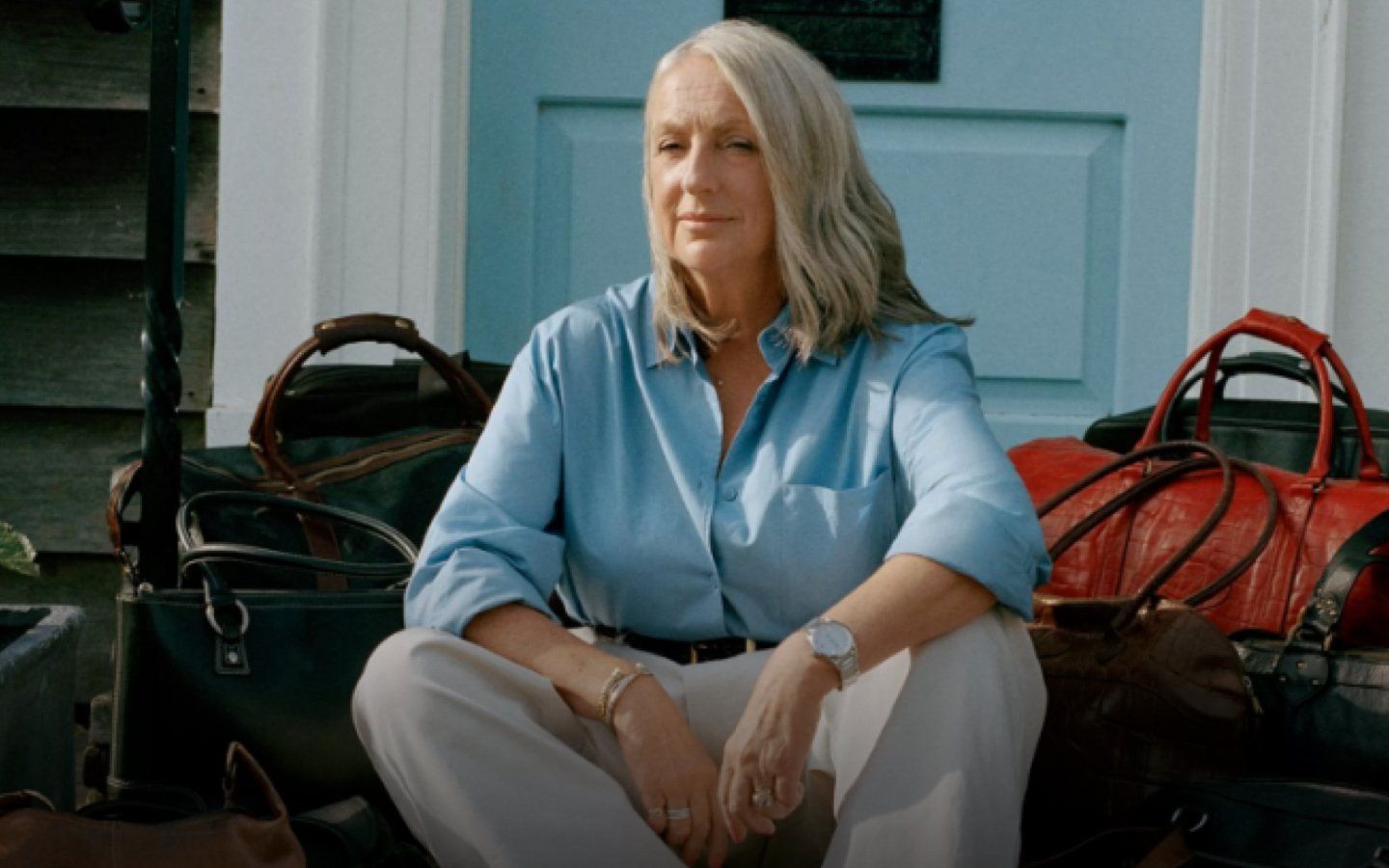 Woman sitting in front of her collection of Mulberry bags