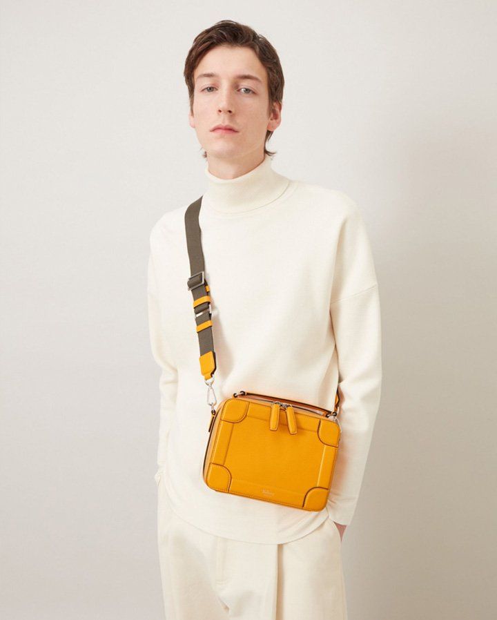 Model wearing the Belgrave Crossbody Messenger bag in yellow leather