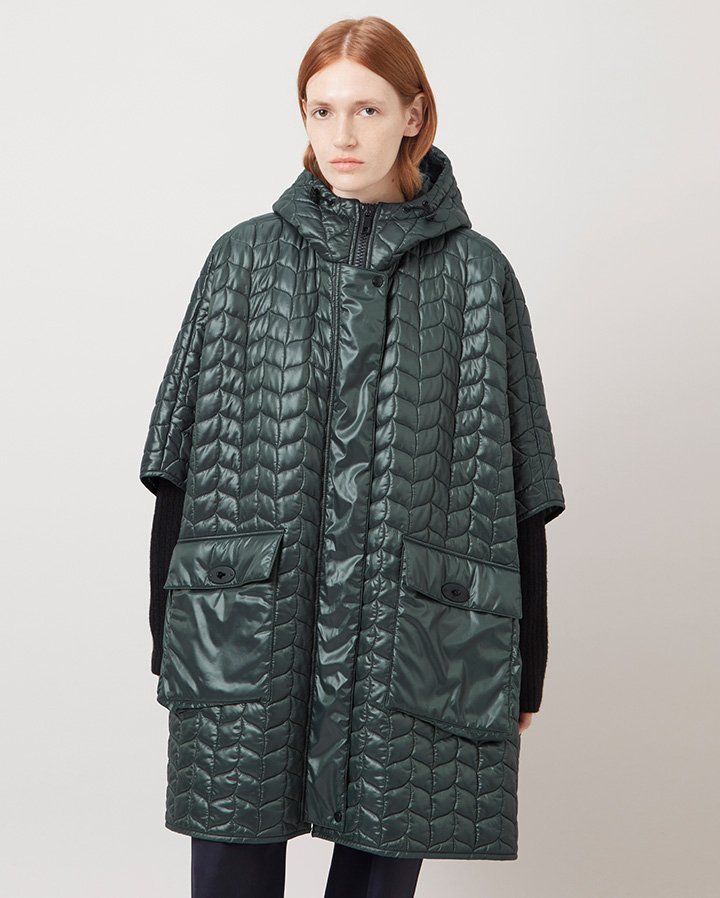 Model wearing the Softie Quilted Hooded Cape in Mulberry Green Recycled Nylon
