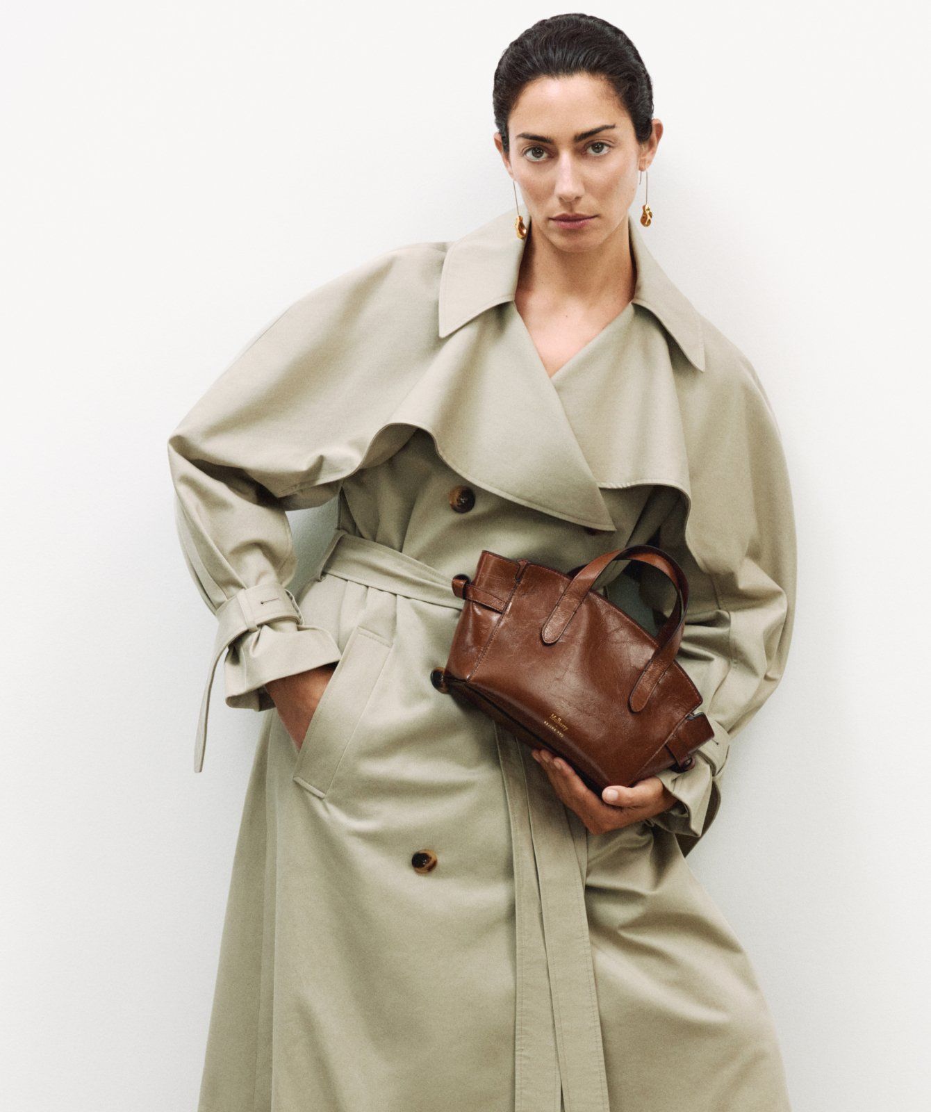 Model holding the Mulberry x Rejina Pyo Rejina Top Handle Crossbody in oak leather