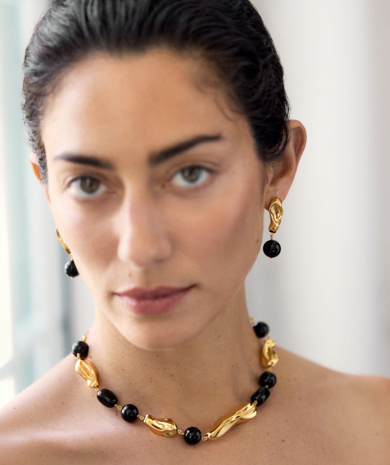 Model wearing the Mulberry x Rejina Pyo Textured Beaded Necklace and Earrings in Gold