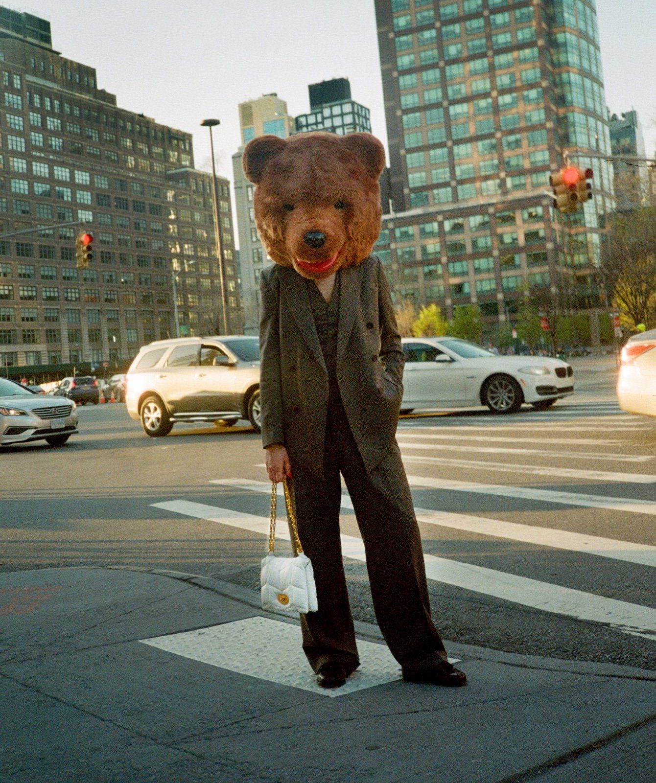 Person with a bear head holding a Softie handbag in white