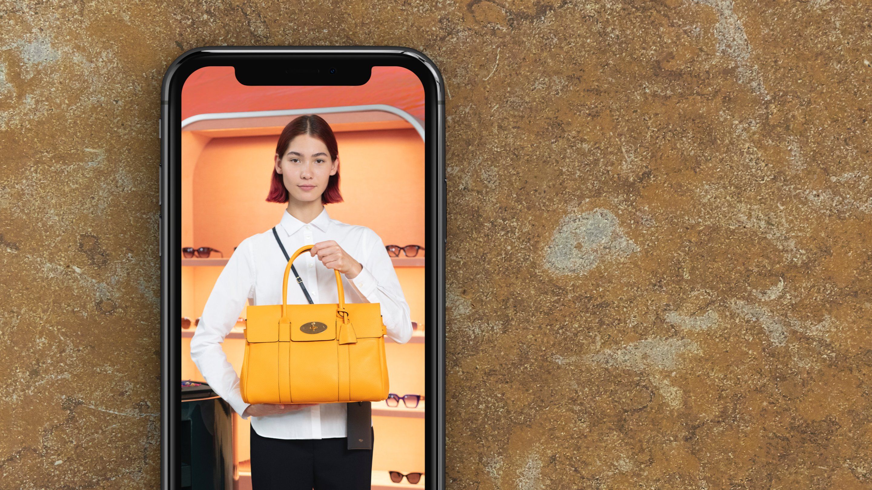 phone showing mulberry employee holding mulberry bayswater bag in yellow
