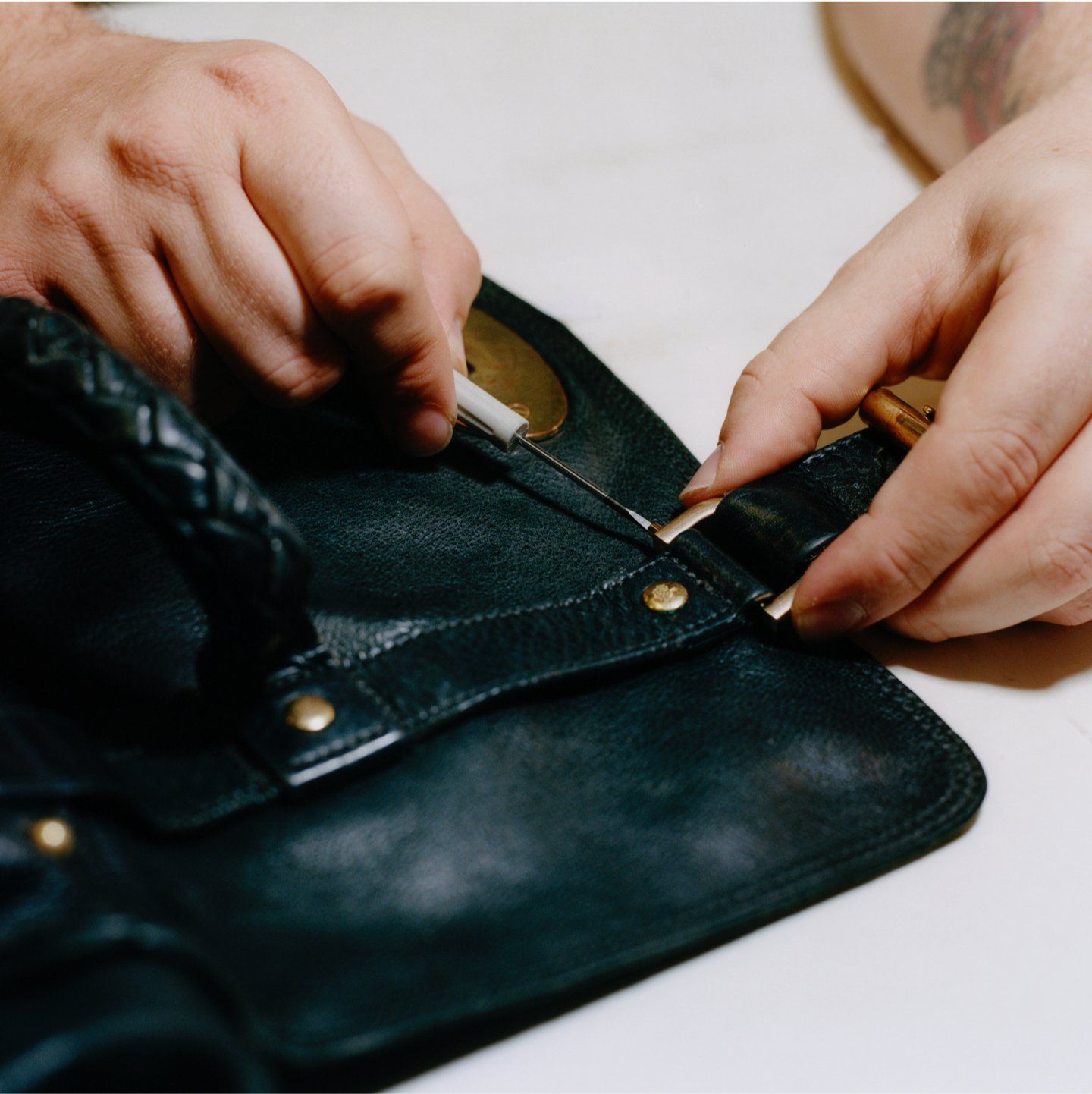 Black leather handbag being repaired