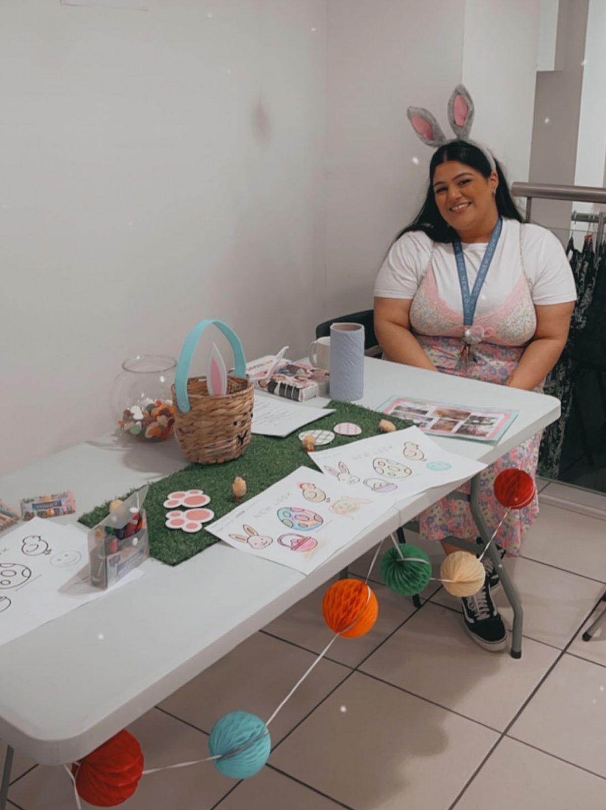 A New Looker sits at the far end of a long white table, wearing bunny ears with Easter decorations on the table