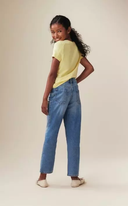 A young model wearing high waisted slouchy straight fit jeans for girls.