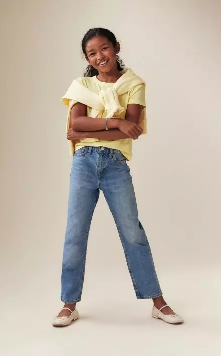 A young model wearing high waisted slouchy straight fit jeans for girls.