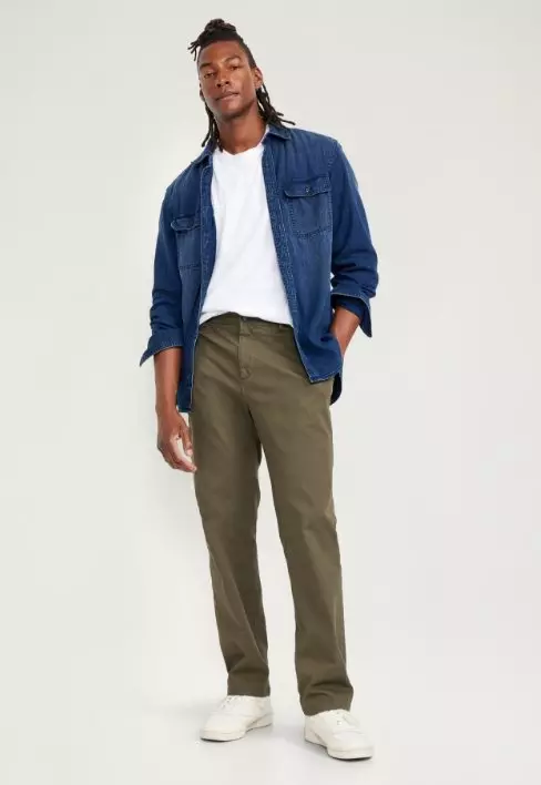 A male model wears loose fit olive green pants.