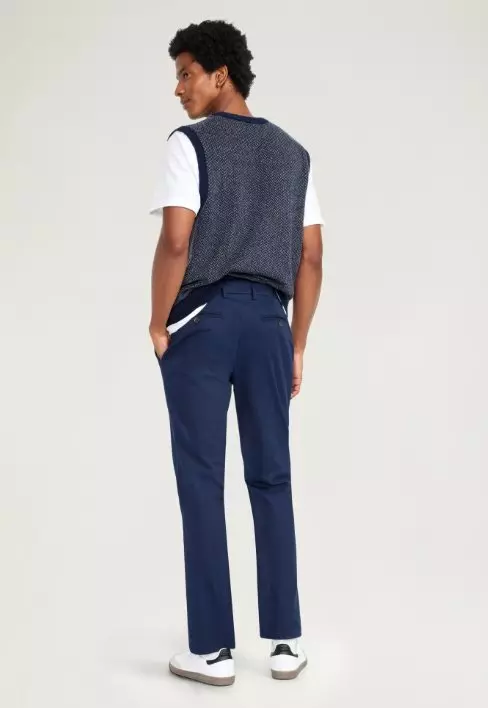 A male model wears straight leg navy blue pants. 