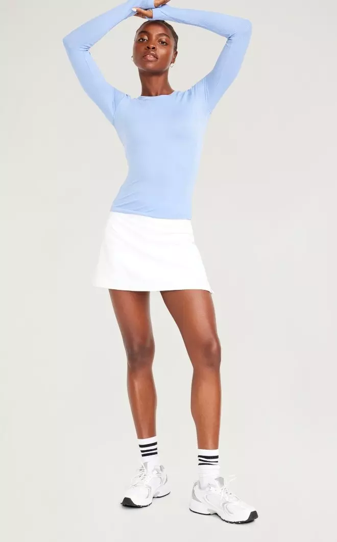 A female model wears a high-waisted Dynamic Fleece Mini Skort