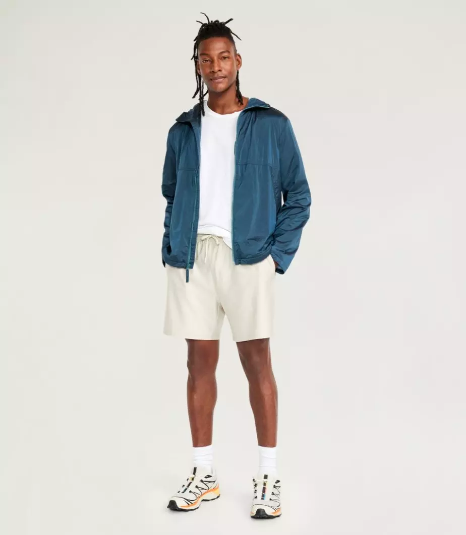A male model wears an active zip up jacket and light colored shorts.