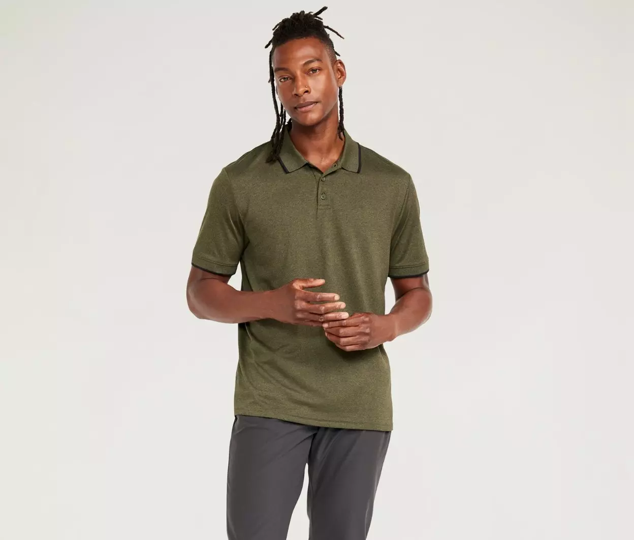 A male model wears a dark green active polo.